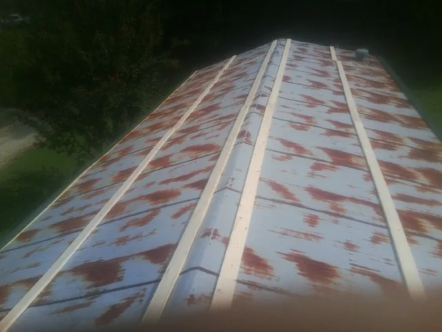 Rusted metal roof panels with new wood purlins before replacement — Storm Damage Roof Repair in Inverness by Roofing Brothers