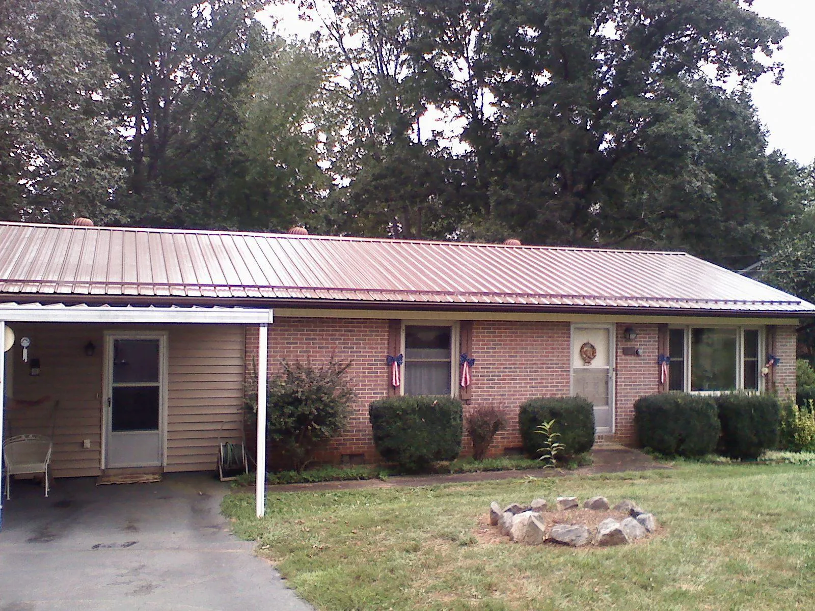 Bronze metal roof and carport on a brick ranch home — Roof Repair work by our crew in Inverness